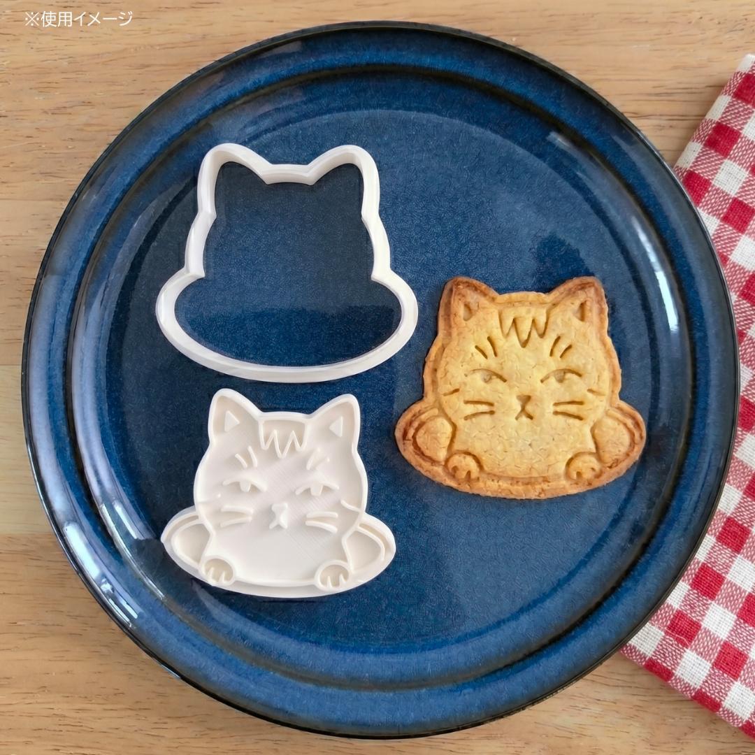 A cat peeking out from a hole, with a glare that's hard to hate. Cat cookie cutter with handle, 55mm.