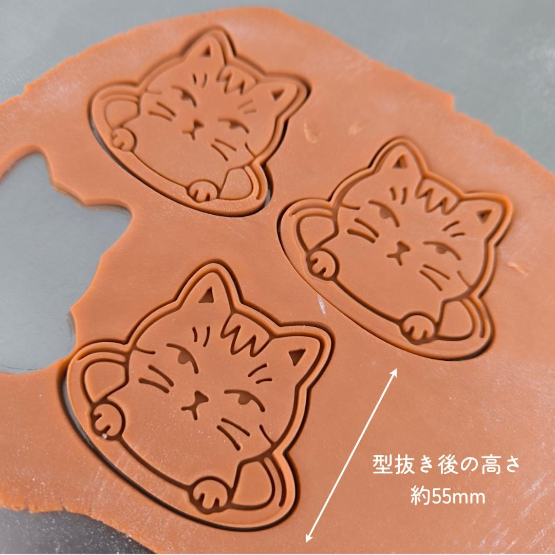 A cat peeking out from a hole, with a glare that's hard to hate. Cat cookie cutter with handle, 55mm.