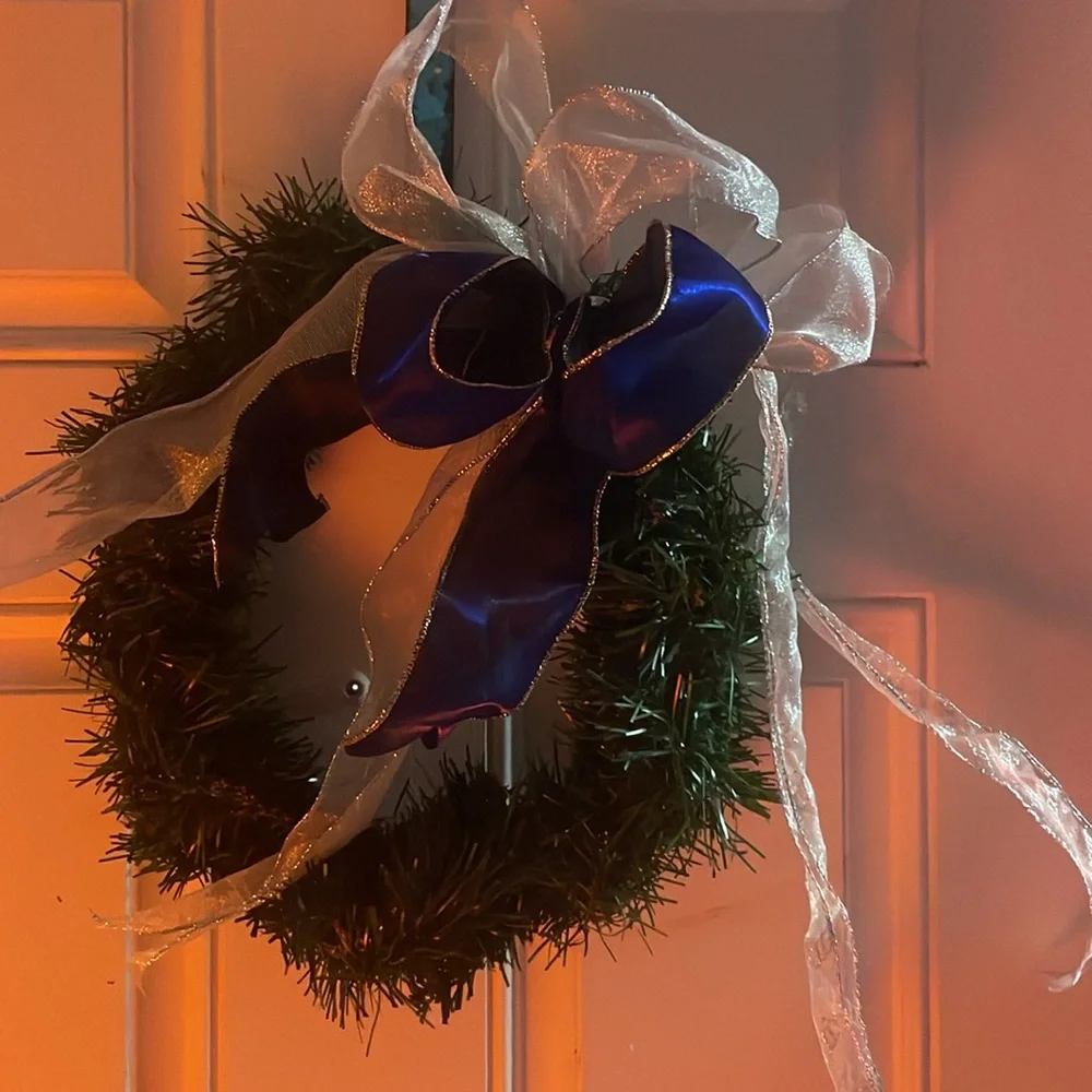 Green Christmas holiday wreath with blue and silver ribbon