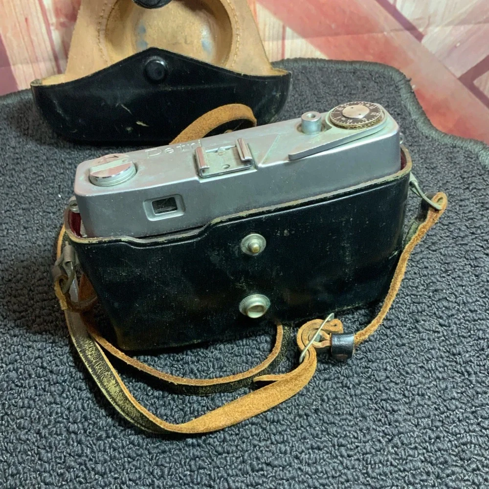 Vintage Petri camera with leather strap and cover.