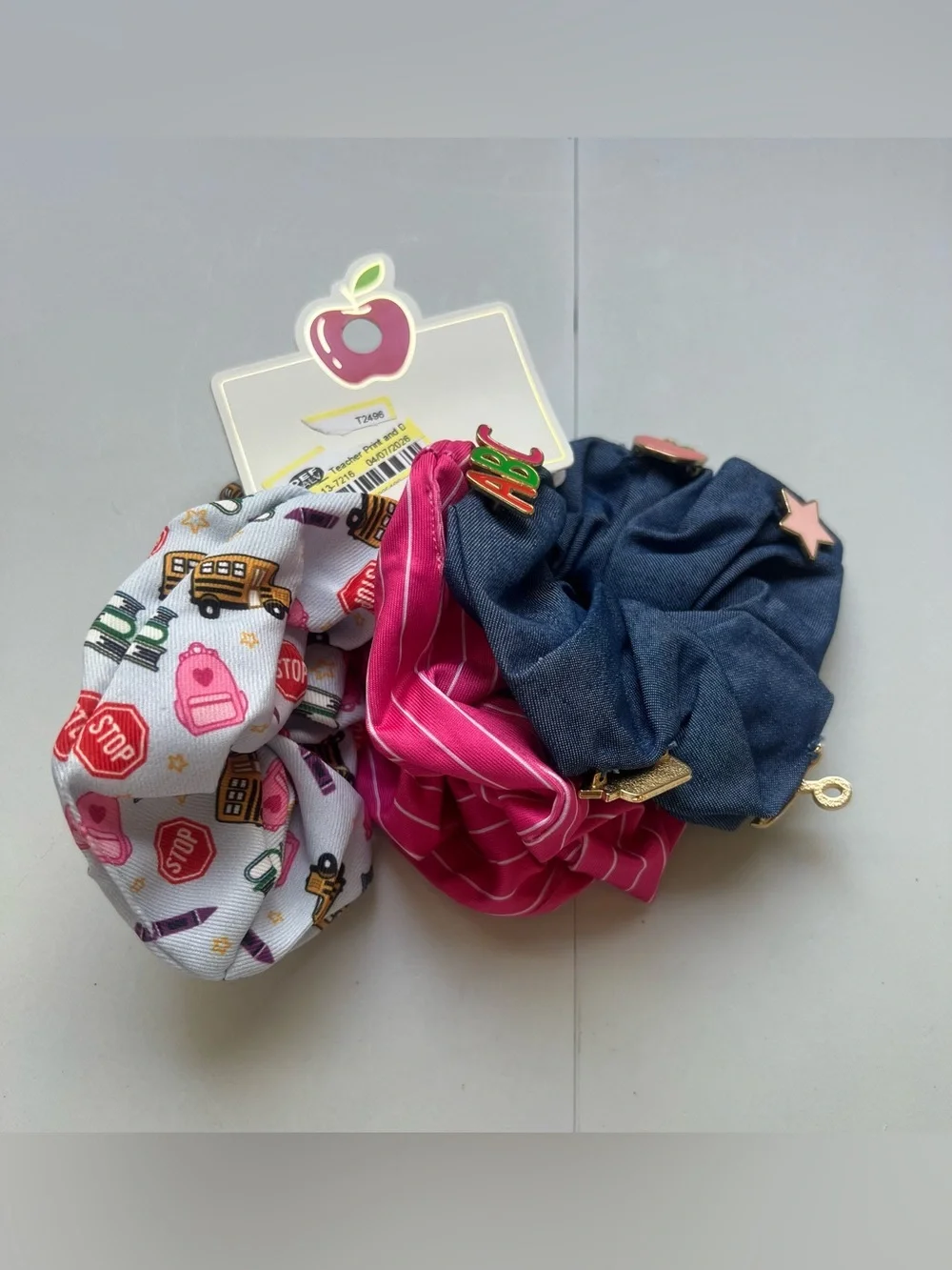 This is a 3-pack of themed hair scrunchies designed with school-related motifs.