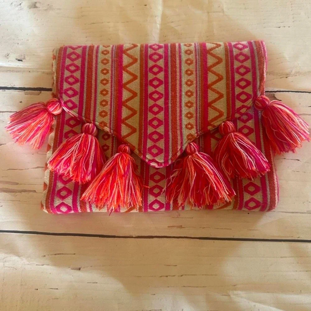 Mudpie Pink and orange embroidered geometric patterned clutch with tassels