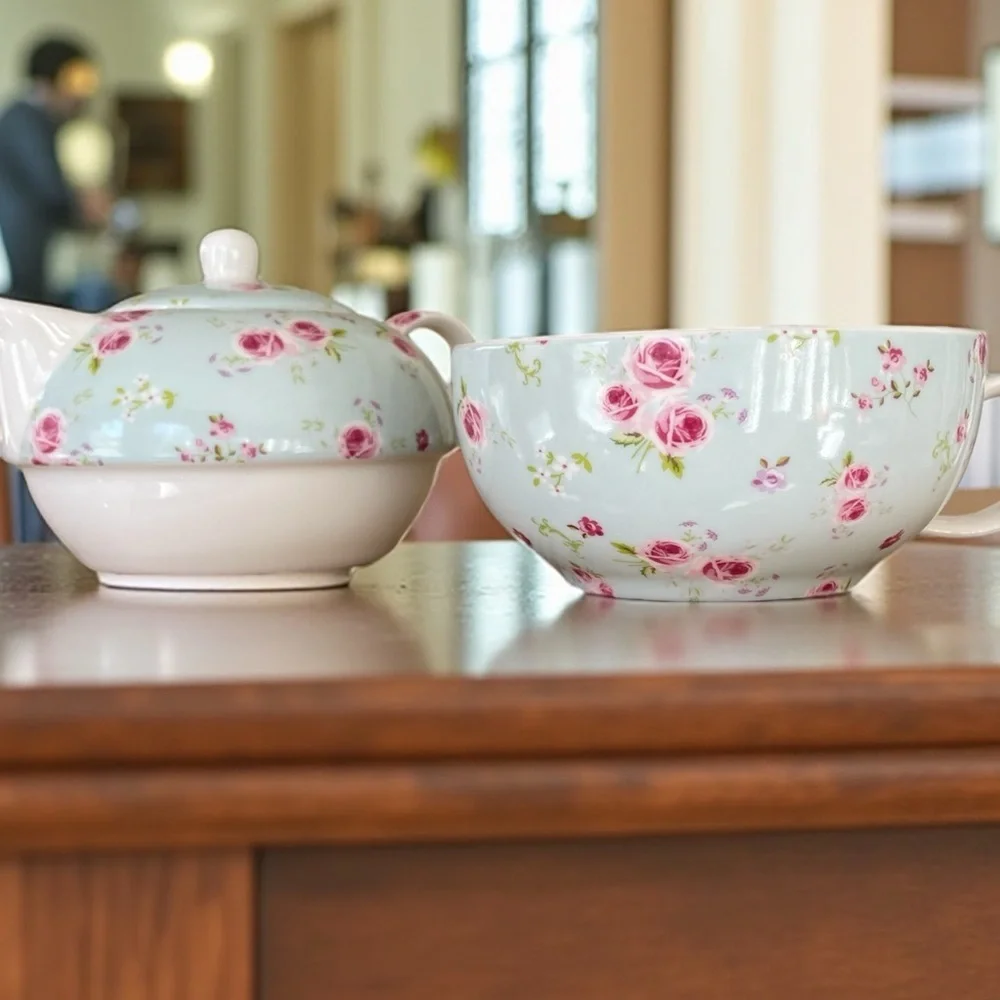 Small teapot with it’s own cup, charming, blue with roses, no flaws