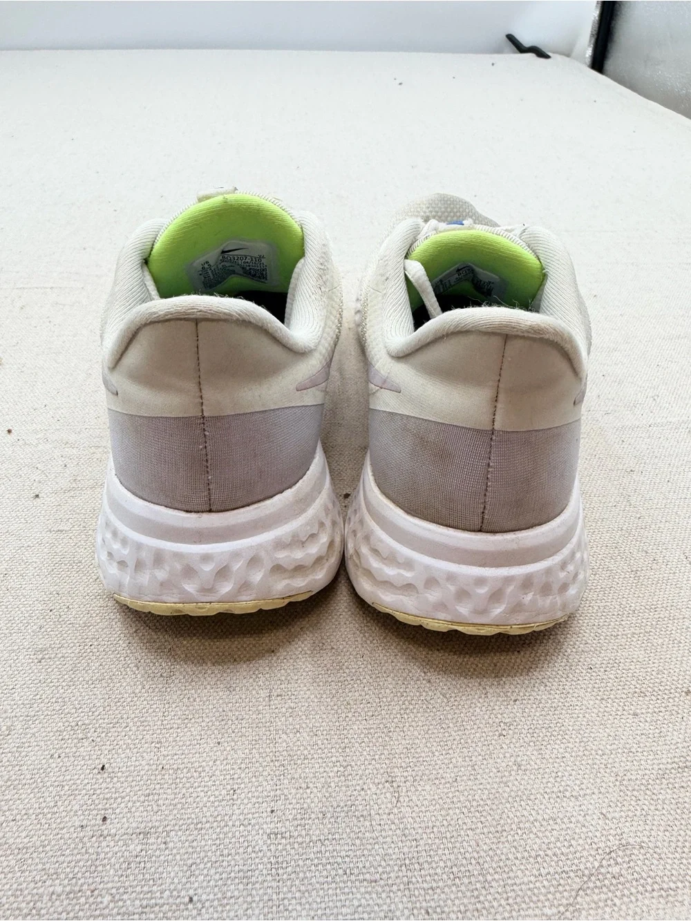 Nike Women’s Revolution Sneakers in Cream with Light Purple Swoosh