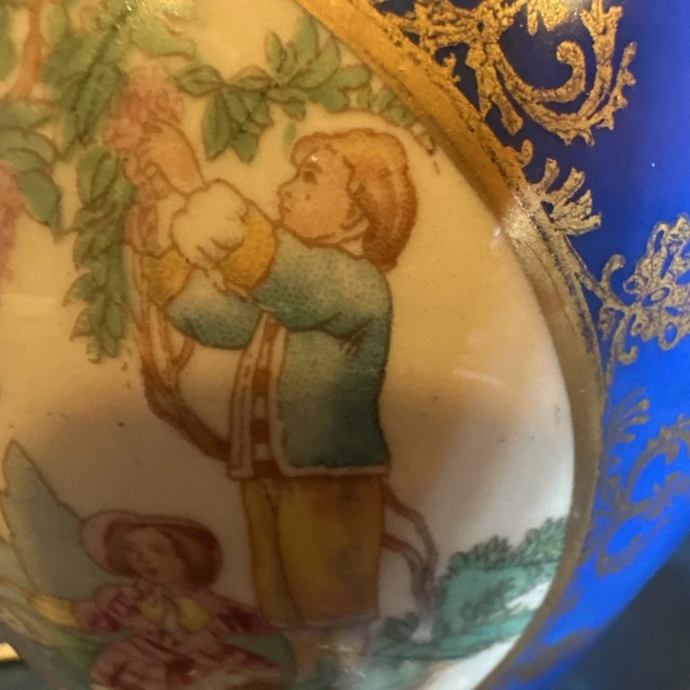 Antique porcelain urn lamp with grape-picking scene.