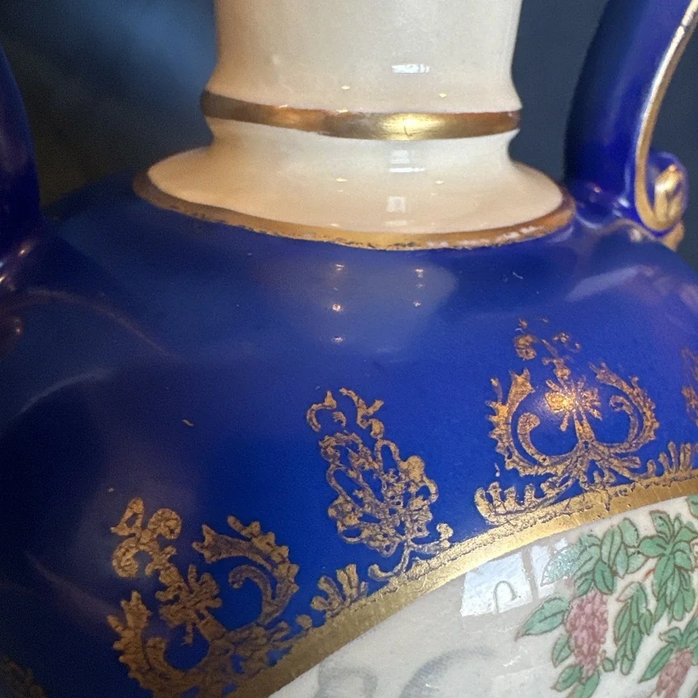 Antique porcelain urn lamp with grape-picking scene.