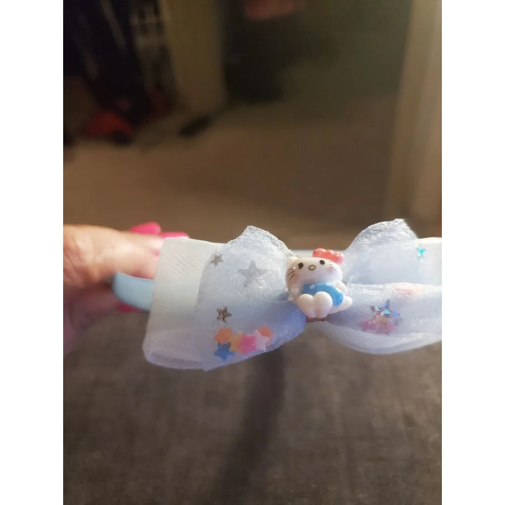 Four Hello Kitty headbands with small figurine