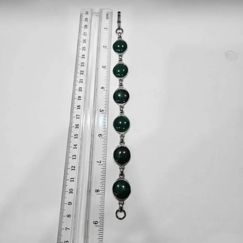 Malachite bracelet features natural green gemstones set in a silver colored link