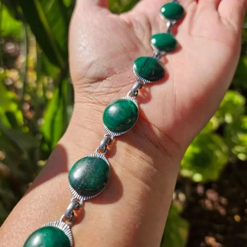 Malachite bracelet features natural green gemstones set in a silver colored link