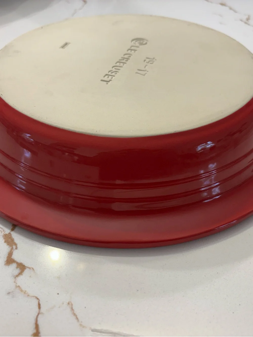 Le Creuset Cerise Red pie baking dish featuring a cream-colored interior.